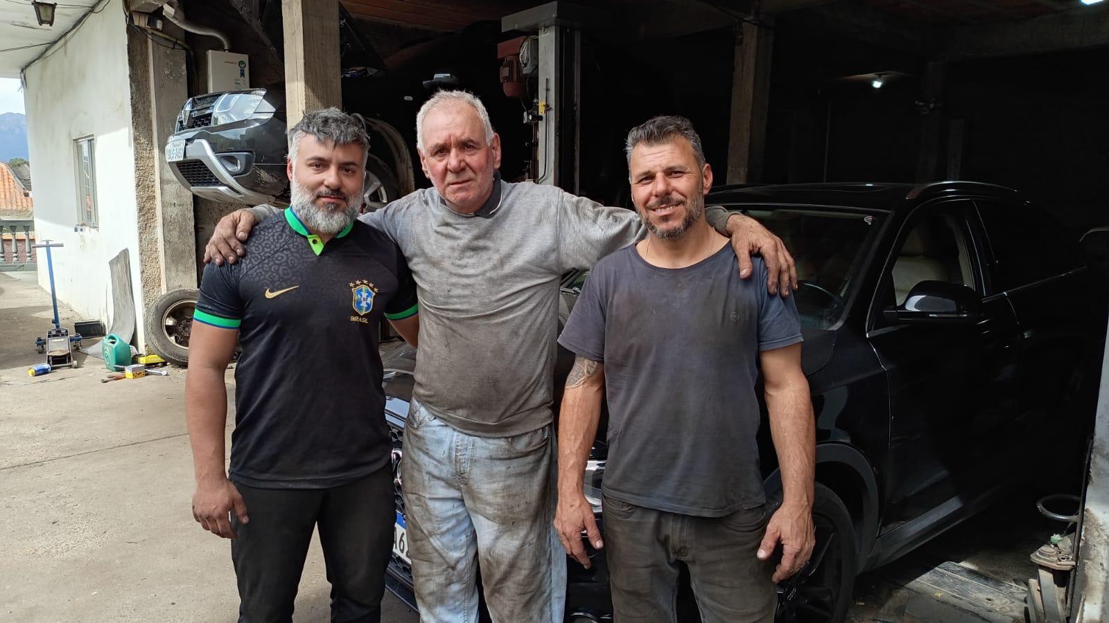 Toninho ao lado dos filhos, Thiago e Eliandro, que hoje dividem a rotina da oficina e dão continuidade à história iniciada há quase cinco décadas